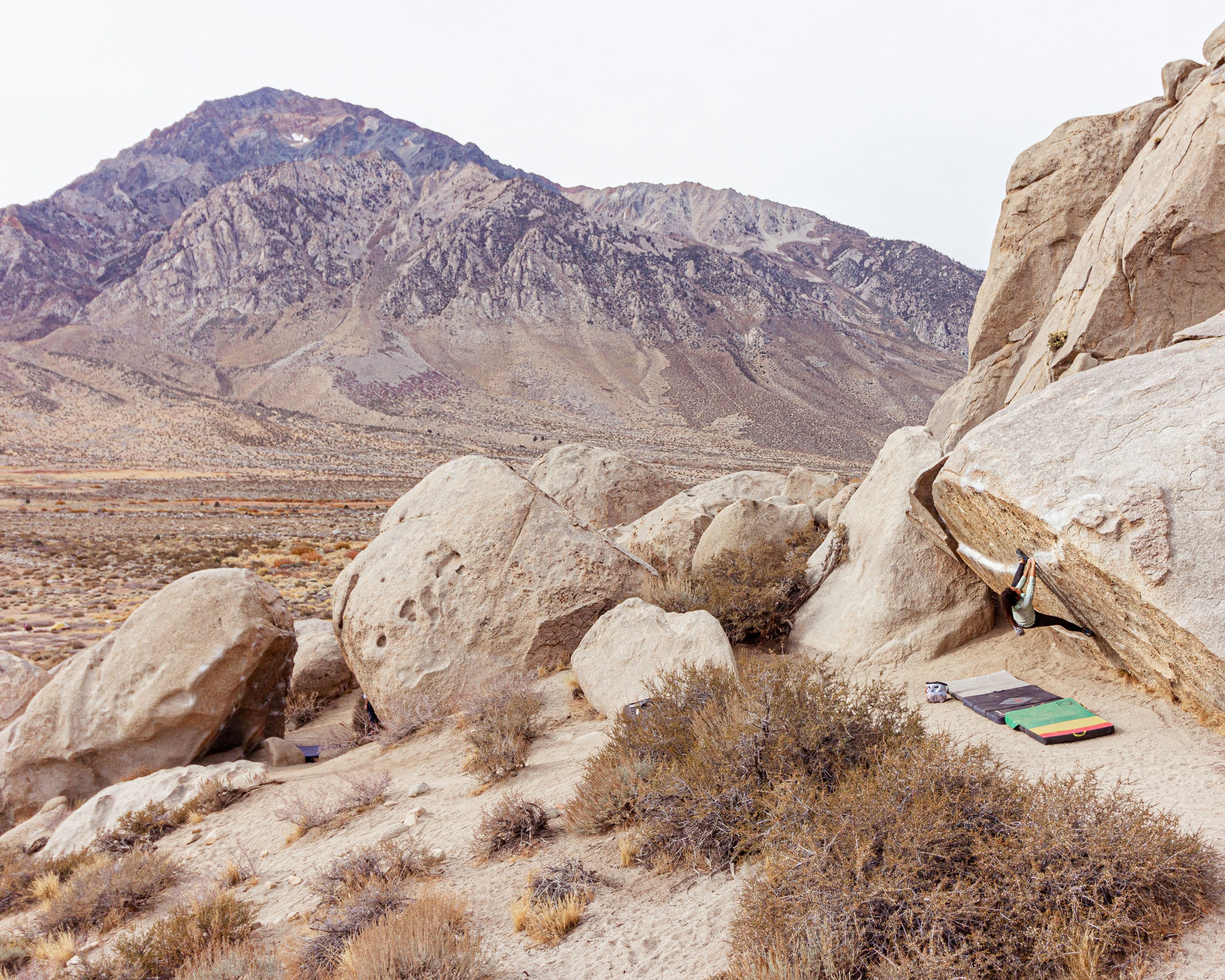 Desert landscape with large rocks and the Eastern Sierra in the background. Ironman Traverse, Buttermilk Boulders, Bishop, CA.