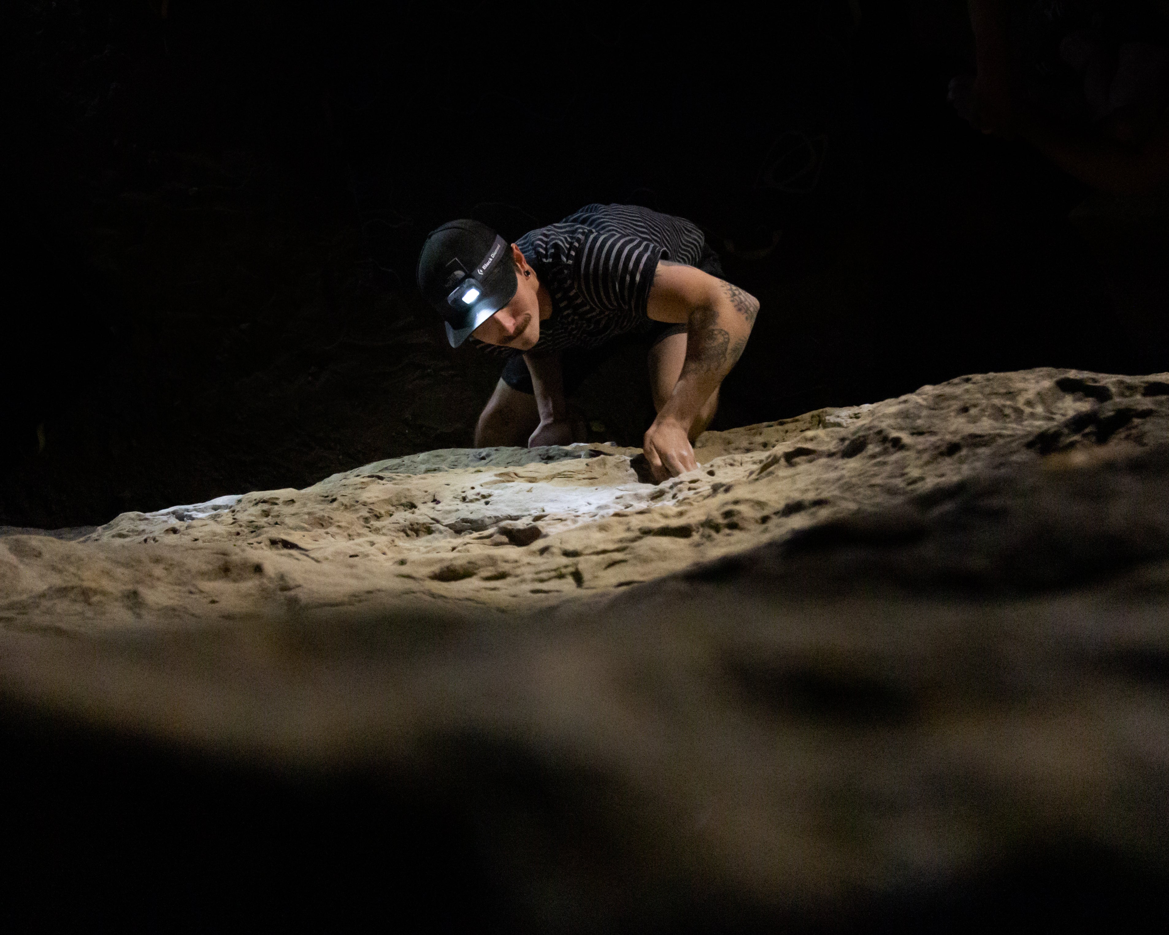 Boulderer climbing sandstone by headlamp. Joe's Valley, Utah.