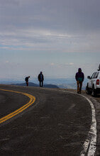 Three people on a high, alpine road. Mt Blue Sky on the road to he summit.
