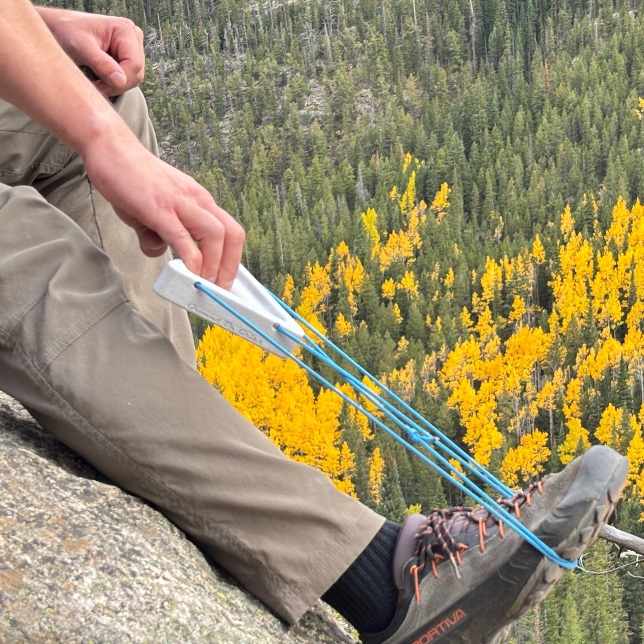 Warm up block for climbing being used against a background of trees and fall foliage.