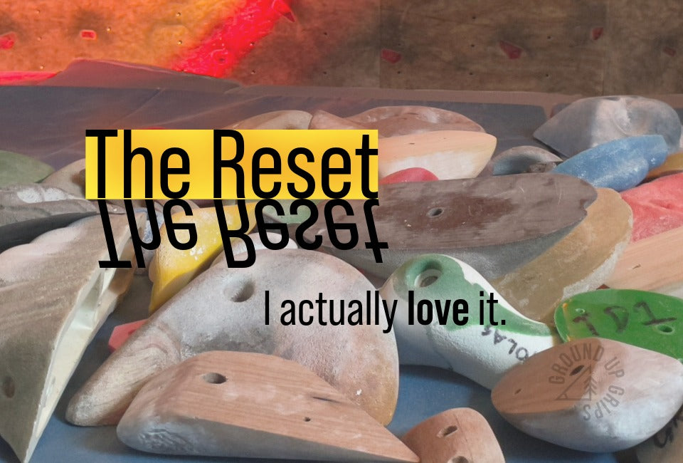 Colorful climbing holds strewn on a mat with the words: "The Reset: I actually love it", overlayed.